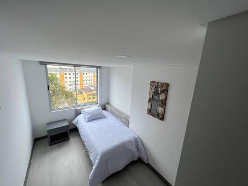 um pequeno quarto com uma cama e uma janela em Edificio apartamentos central con ascensor 502 em Bogotá