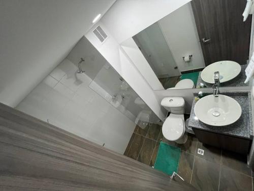 a bathroom with a sink and a toilet and a mirror at Edificio apartamentos central con ascensor 502 in Bogotá