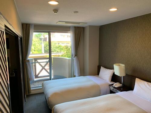 富士河口湖的住宿－Kawaguchiko Park Hotel，酒店客房设有两张床和窗户。