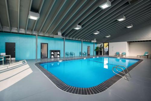 een groot zwembad in een gebouw met blauwe muren bij Best Western New Oregon Motel in Eugene