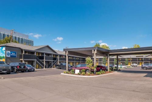 a parking lot with cars parked in front of a building at Best Western New Oregon Motel in Eugene