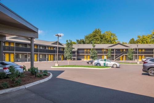 a building with cars parked in a parking lot at Best Western New Oregon Motel in Eugene