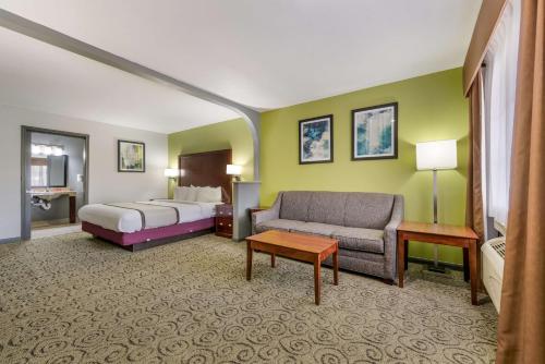 a hotel room with a bed and a couch at SureStay Hotel by Best Western Deer Park in Deer Park