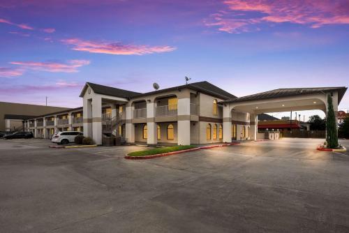 a large building with a parking lot in front of it at SureStay Hotel by Best Western Deer Park in Deer Park
