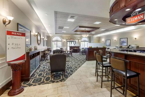 a lobby with a bar and a restaurant with chairs at Best Western Plus Orillia Hotel in Orillia