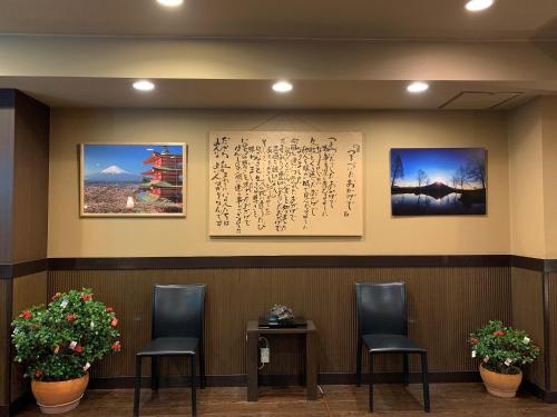 a waiting room with three chairs and a wall with certificates at Kawaguchiko Park Hotel in Fujikawaguchiko