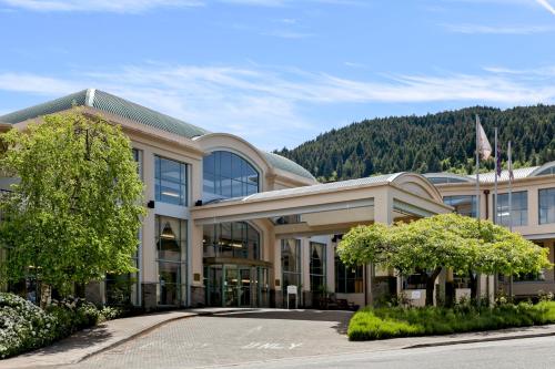 a large building with a flag on top of it at Millennium Hotel Queenstown in Queenstown