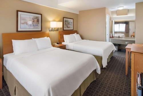 Habitación de hotel con 2 camas y baño en SureStay Hotel by Best Western North Vancouver Capilano, en North Vancouver