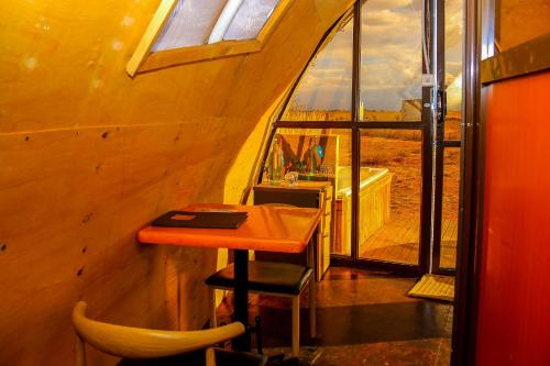 a small table and chairs in a room with a window at Amanya 2-Bed Lioness Family Tent in Amboseli in Amboseli