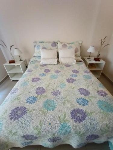 1 dormitorio con 1 cama con colcha colorida en Dpto Brown Salta en Salta