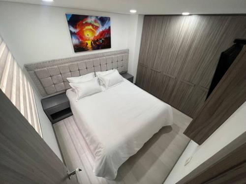 Un pequeño dormitorio con una cama blanca en una habitación en Aparta estudios central Con ascensor 503, en Bogotá
