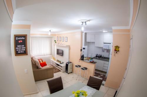 a kitchen and a living room with a table and chairs at Apartamento Mari 1 in São Carlos