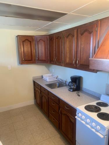 een keuken met houten kasten en een witte kookplaat bij ELIS APARTMENT in Ocean City