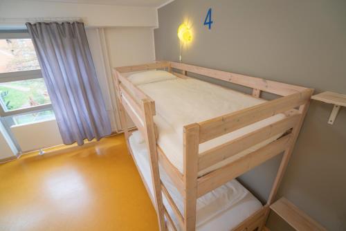 a wooden bunk bed in a room with a window at BIG MAMA Berlin in Berlin