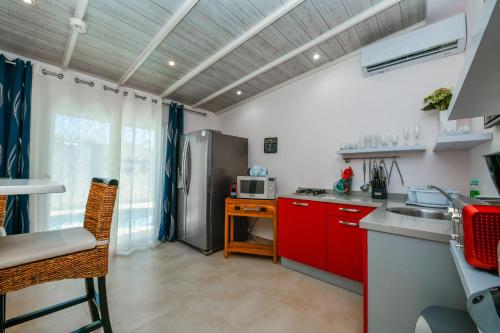 a kitchen with red cabinets and a stainless steel refrigerator at Boutique Hotel Swiss Paradise Aruba Villas and Suites in Palm-Eagle Beach