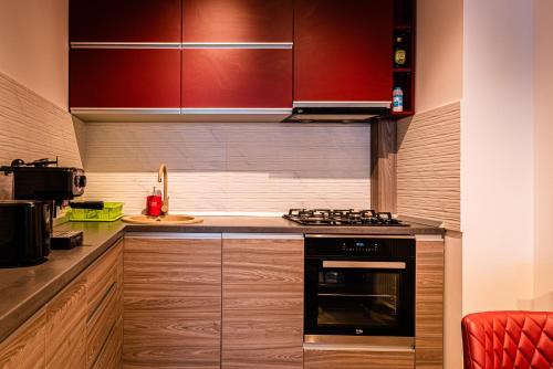 una cucina con armadi rossi e un piano cottura. di Adonis Albu's Residence a Braşov