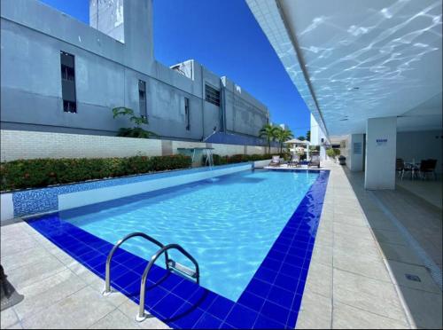 una gran piscina azul en un edificio en Flat beira mar Tambaú, en João Pessoa