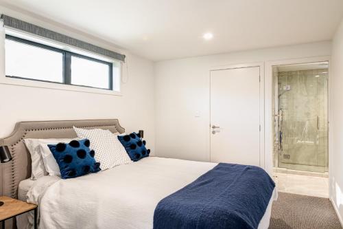 a bedroom with a bed with blue and white pillows at Blue House on the Quay in Motueka