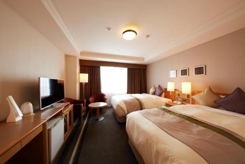 Habitación de hotel con 2 camas y TV de pantalla plana. en Keio Plaza Hotel Hachioji, en Hachioji