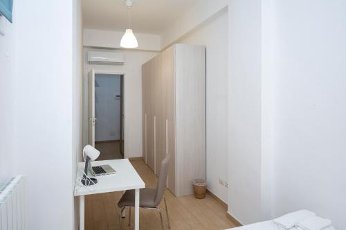 a white room with a desk with a laptop on it at Rucellai Guest House in Milan