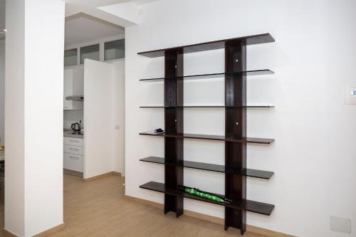 a book shelf in a living room with black shelving at Rucellai Guest House in Milan