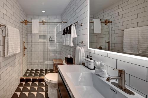 a bathroom with a sink and a toilet and a mirror at The Montauk Beach House in Montauk