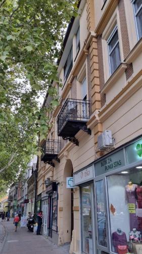 a building on the side of a street with a store at Apartment Kiki in Novi Sad