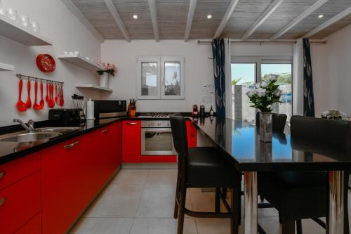a kitchen with red cabinets and a black counter top at Boutique Hotel Swiss Paradise Aruba Villas and Suites in Palm-Eagle Beach