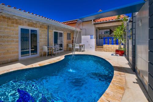 a swimming pool in the backyard of a house at Boutique Hotel Swiss Paradise Aruba Villas and Suites in Palm-Eagle Beach