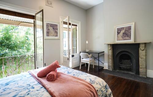 a bedroom with a bed with a fireplace and a desk at Kent Terrace in Sydney