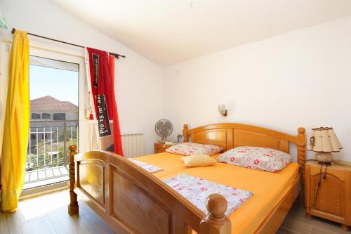 1 dormitorio con cama de madera y ventana en Apartments by the sea Businci, Ciovo - 9450, en Trogir