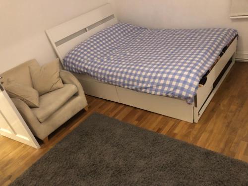 a bedroom with a bed and a chair and a rug at Common 2 in London