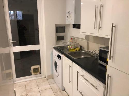 a kitchen with a sink and a washing machine at Common 2 in London