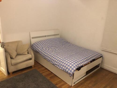 a small bedroom with a bed and a chair at Common 2 in London
