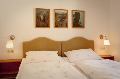 a bedroom with two beds and three pictures on the wall at Berghof Lichtenhain in Lichtenhain