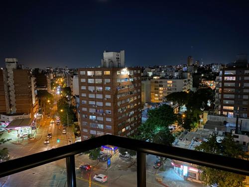 a view of a city at night from a balcony at EUGE Apart in Montevideo