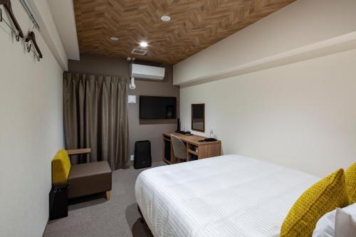 a bedroom with a bed and a desk and a television at Hotel Reference Tenjin III in Fukuoka