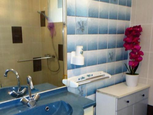 uma casa de banho com lavatório, espelho e flores em Gîte Bais, 4 pièces, 7 personnes - FR-1-600-19 em Bais