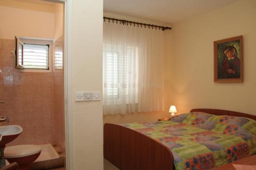 a bedroom with a bed and a bathroom with a sink at Apartments by the sea Orebic, Peljesac - 10436 in Orebić