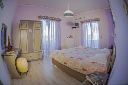 a bedroom with a large bed and a mirror at Dimitropoulos Apartments in Eleonas