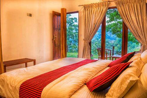 a bedroom with a large bed with a large window at Eminence ella in Ella