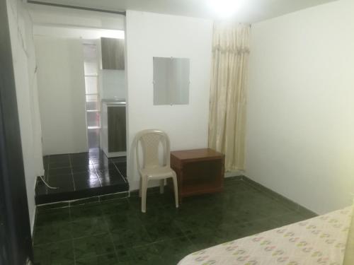 a bedroom with a chair and a desk and a bed at ApartaEstudio Jazmines Santa Rosa de Cabal in Santa Rosa de Cabal