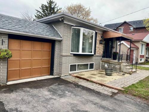 a house with a brown garage door in a driveway at Cosy 5 Bedrooms House in Hearth of Richmond Hill in Richmond Hill