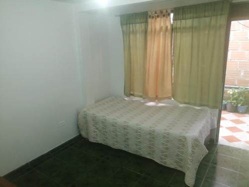 a room with a table and a window with curtains at ApartaEstudio Jazmines Santa Rosa de Cabal in Santa Rosa de Cabal