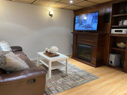 a living room with a couch and a tv at Cosy 5 Bedrooms House in Hearth of Richmond Hill in Richmond Hill