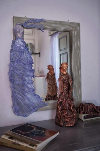 a mirror and two figurines sitting on a table at Dimitropoulos Apartments in Eleonas