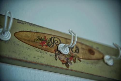a surfboard is attached to a wall with hooks at Dimitropoulos Apartments in Eleonas