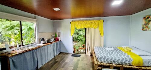 ein Schlafzimmer mit einem Bett und einem großen Fenster in der Unterkunft The Frog House in Fortuna