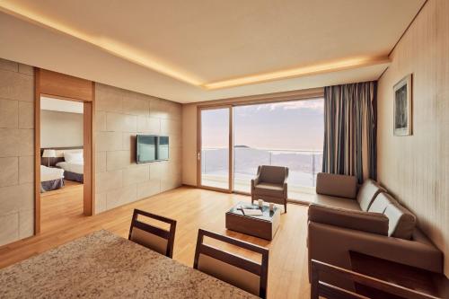 ein Wohnzimmer mit Sofa und ein Schlafzimmer in der Unterkunft Sono Calm Geoje in Geoje