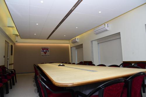 a conference room with a table and chairs and a screen at YMCA International House in Mumbai